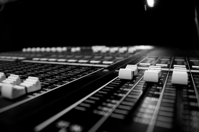 Studio mixing console with glowing faders.